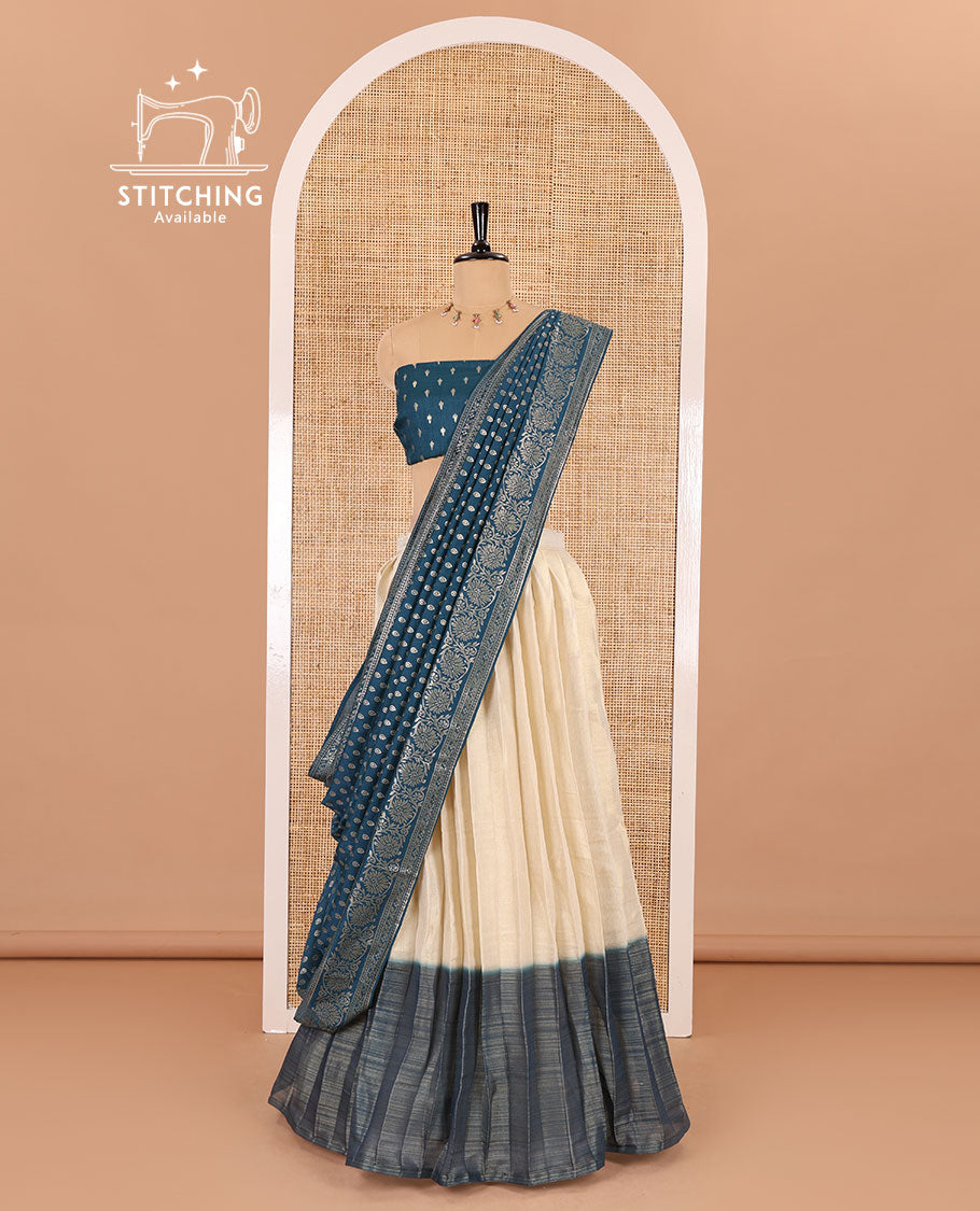 Cream-peacock blue Vichitra half-saree, plain and contrast bordered skirt, contrast leaf buttas blouse, dhavani of buttas and floral creeper designs