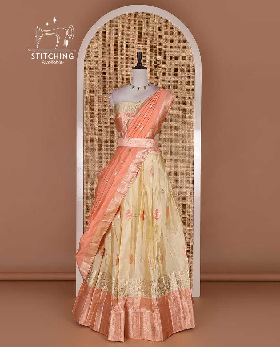 Cream taffeta silk half saree, meena buttas skirt, contrast peach traditional zari border, matching blouse, and zari woven dhavani