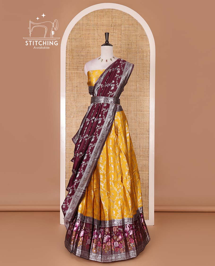Haldi yellow taffeta silk half saree, floral jaal jacquard skirt, contrast wine zari meenakari style bird border, matching blouse, and floral jaal dhavani
