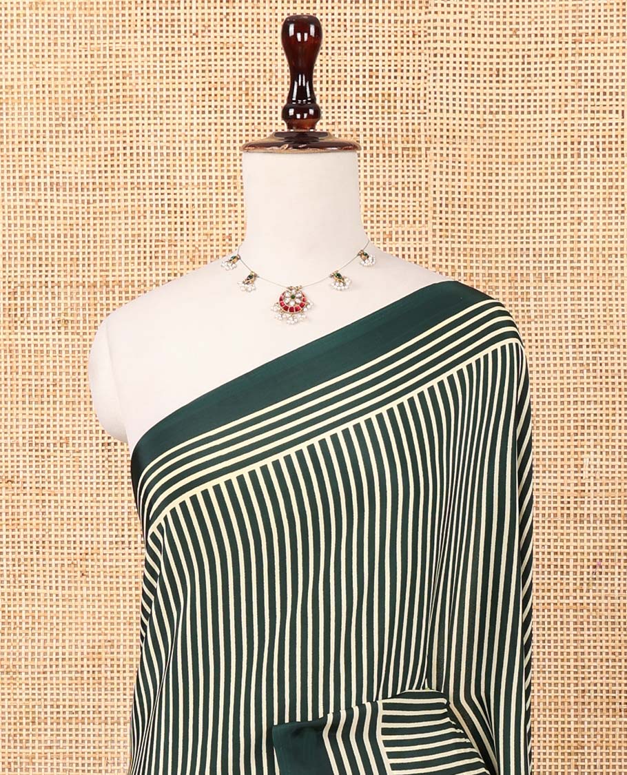 Bottle green vertical stripes printed modal satin saree, a self-border of horizontal stripes print, polka dots printed on the pallu, and an intricate ajrakh-style printed blouse