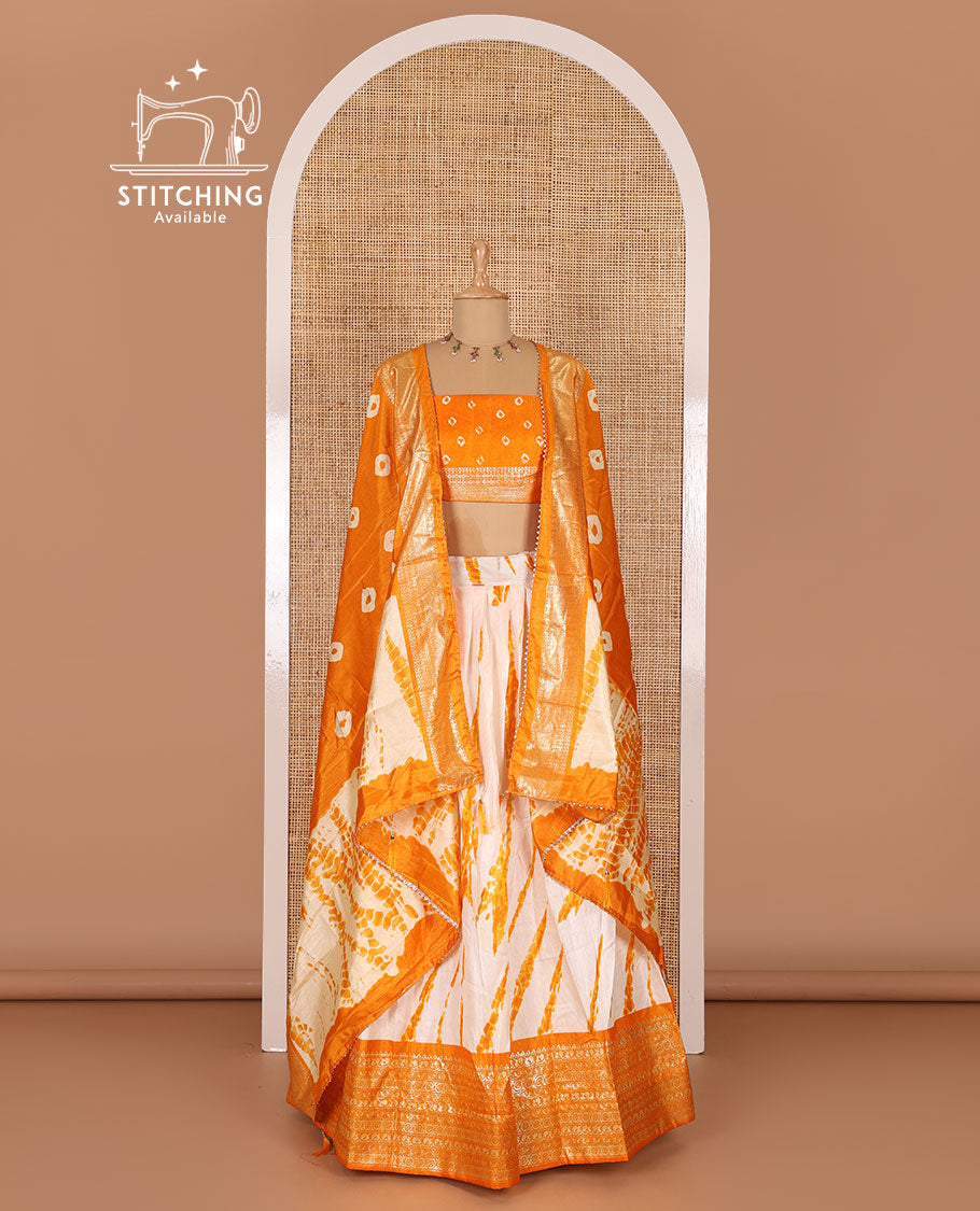 Cream and yellow semi-tussar half-saree, shibori printed with contrast geometric patterned bordered skirt, bandhani printed blouse, and bandhani printed dhavani