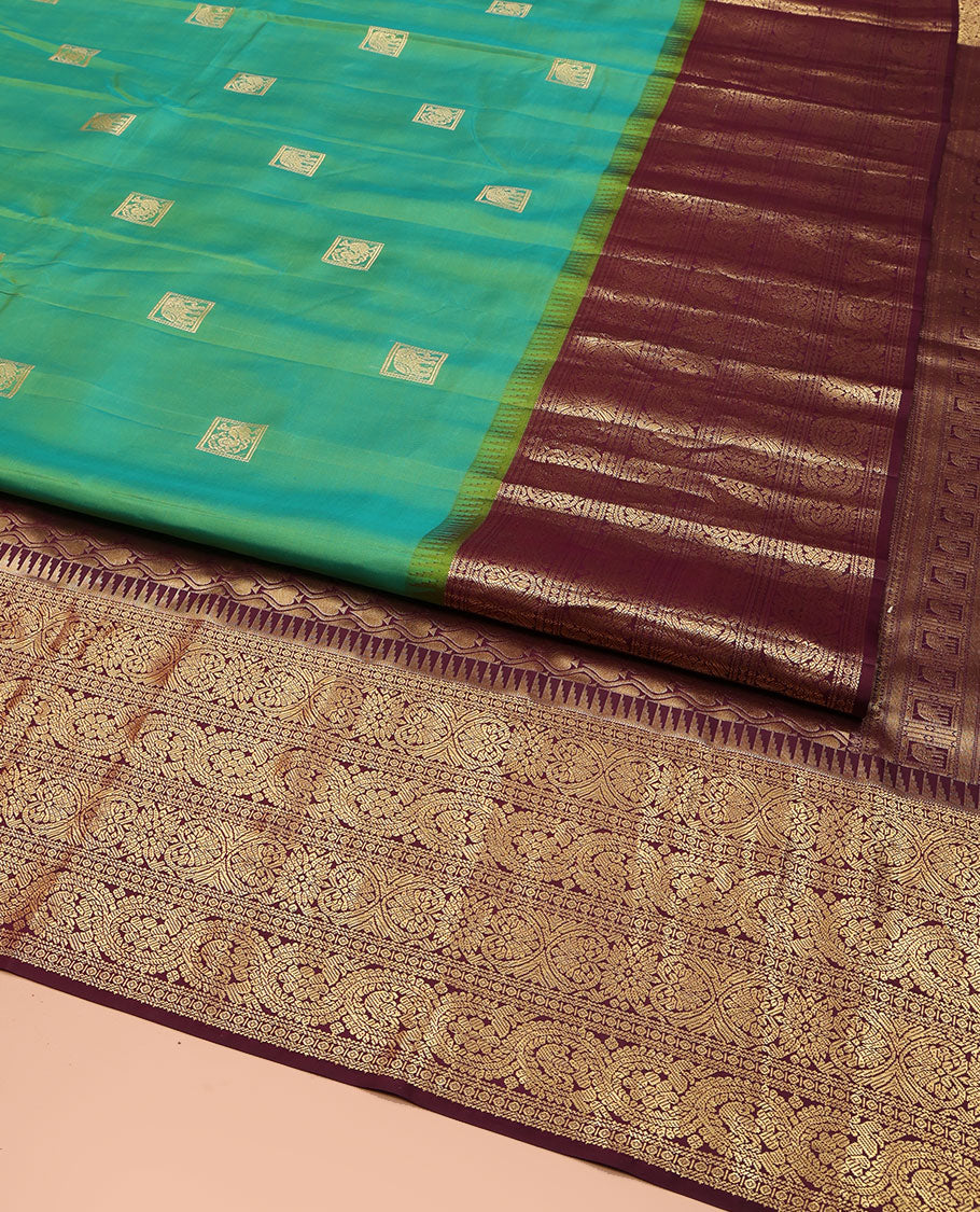 Sea Green Vasundhara Silk Saree, Accentuated with Zari Buttas All Over Its Body, Complemented by Contrast Border of Ara Bogudi, Banaras, Jada Nagam and Dhavana Kodi Designs, Pallu of Intricate Designs, and Paired with a Contrast Blouse