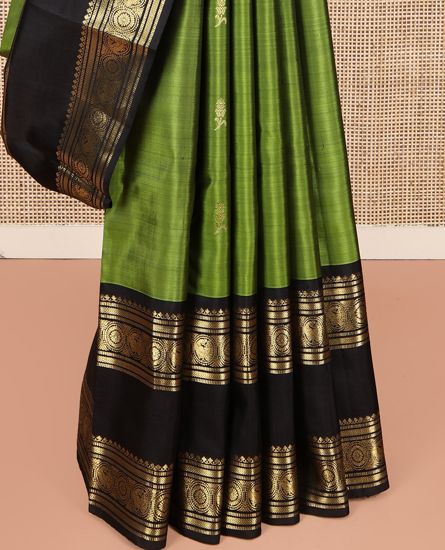 Green Kanchipuram Silk Saree, Ornamented with Zari Buttas All Over Its Body, Complemented by a Contrast Rettai Pettu Border of Salngai, Muthu, Kathir, Chakram, and Round Mayil Designs, Grand Pallu, and Paired with a Contrast Blouse