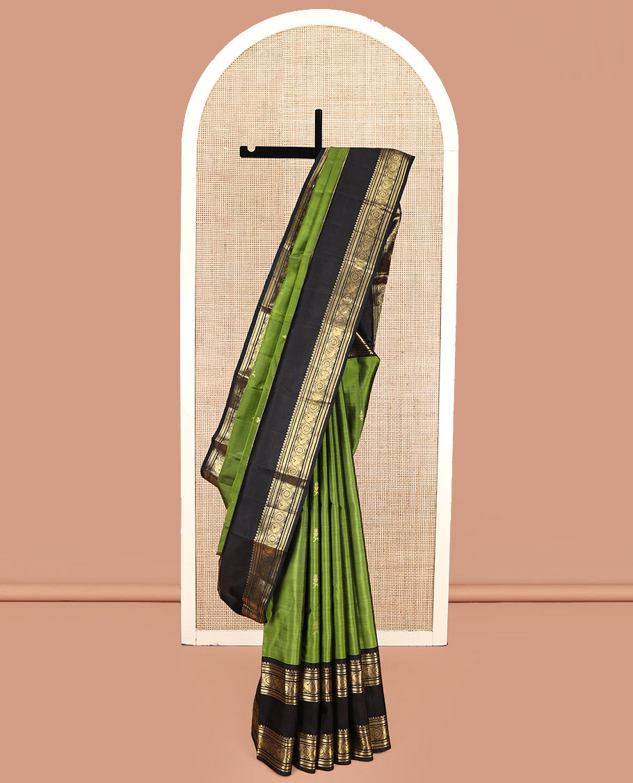 Green Kanchipuram Silk Saree, Ornamented with Zari Buttas All Over Its Body, Complemented by a Contrast Rettai Pettu Border of Salngai, Muthu, Kathir, Chakram, and Round Mayil Designs, Grand Pallu, and Paired with a Contrast Blouse