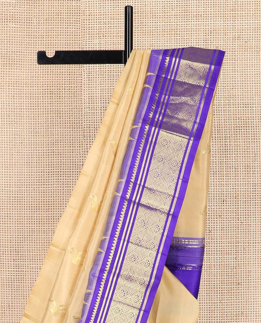 Light sandal yaanai buttas Kanchipuram silk saree, contrast one-sided thazampoo rekku border of thilakam mokku, banaras, and jaal designs, and floral jaal pallu