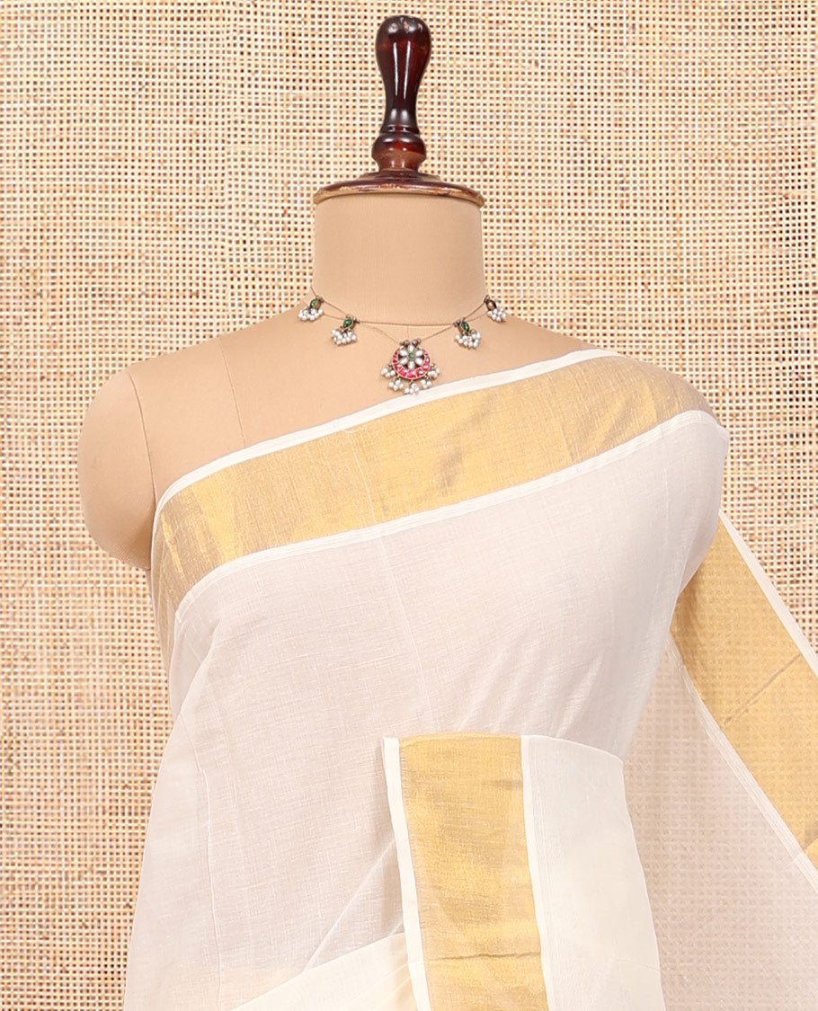Cream Plain Kerala Cotton Saree, a Subtle Bavanji Border, Gleaming Zari Pallu, and Is Paired with a Matching Blouse