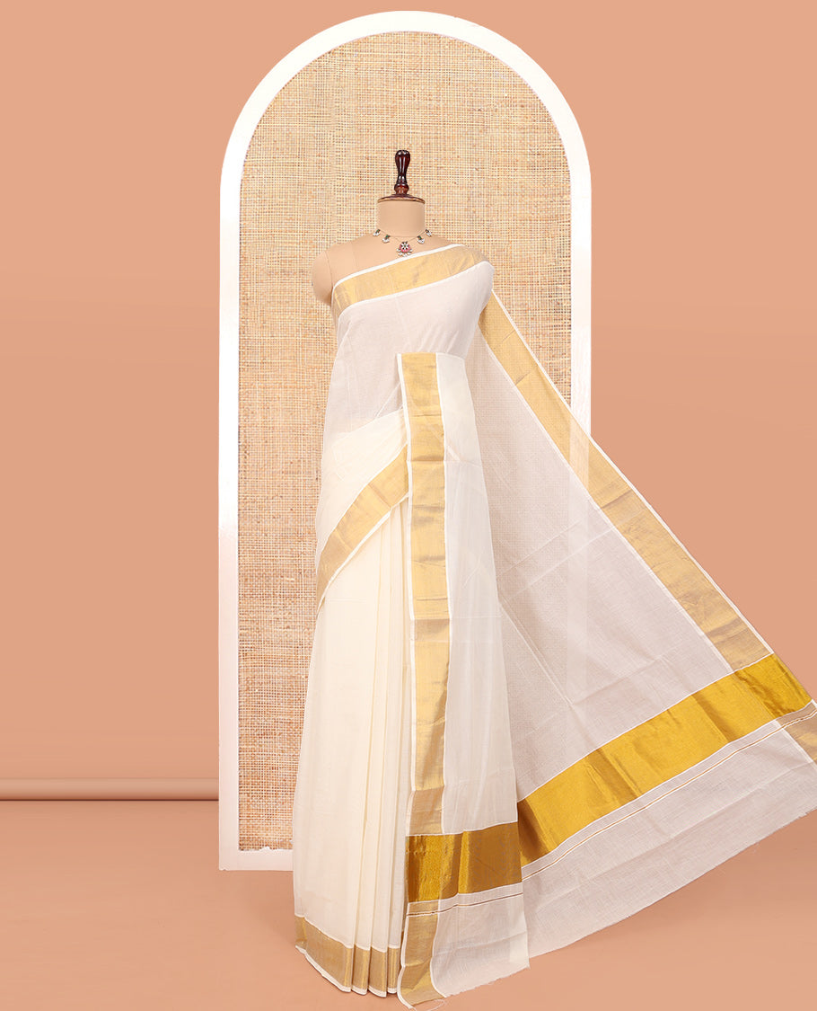 Cream Plain Kerala Cotton Saree, a Subtle Bavanji Border, Gleaming Zari Pallu, and Is Paired with a Matching Blouse