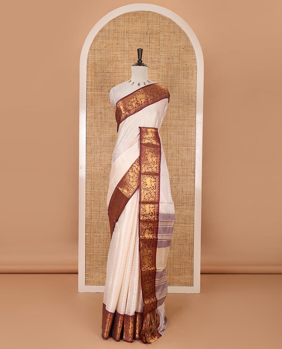 Half-white zari checked semi-taffeta silk saree, contrast maroon deer motifs woven border, striped pallu & contrast striped zari border blouse
