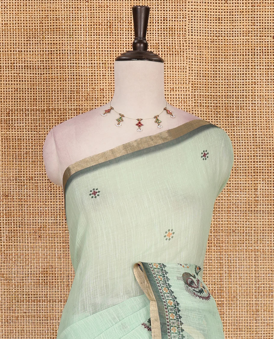 Green buttas with mirror work linen saree, zari border with peacock motifs print, printed mirror work pallu, and matching blouse