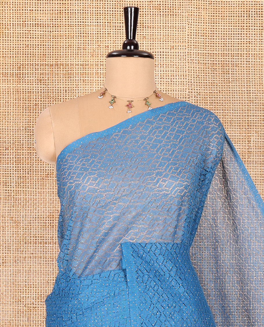 Borderless blue sparkling glitter russel net saree with self-pallu, and a contrast floral printed and zig-zag patterned blouse