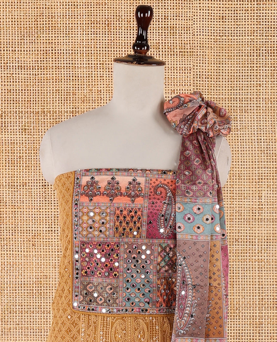 Mustard churidar material set, Ajrakh-printed neck with Schiffli embroidery & mirror work georgette top, kalidoscopic-colored dupatta of ajrakh print & mirror embroidery & plain crepe bottom