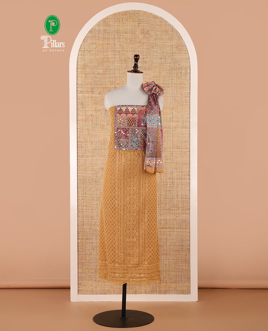 Mustard churidar material set, Ajrakh-printed neck with Schiffli embroidery & mirror work georgette top, kalidoscopic-colored dupatta of ajrakh print & mirror embroidery & plain crepe bottom