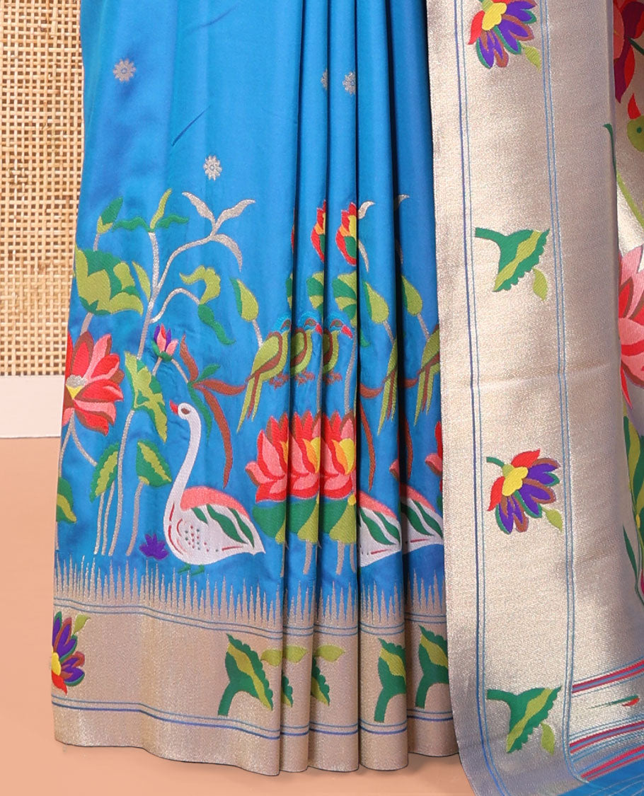Blue Paithani Art Silk Saree, Accentuated with Flower Buttas All Over Its Body, Highlighted by Zari Temple Border Pictures Colorful Flora-Fauna Designs, Pallu Depicts Colorful Floral and Bird Designs, and Paired with a Matching Blouse