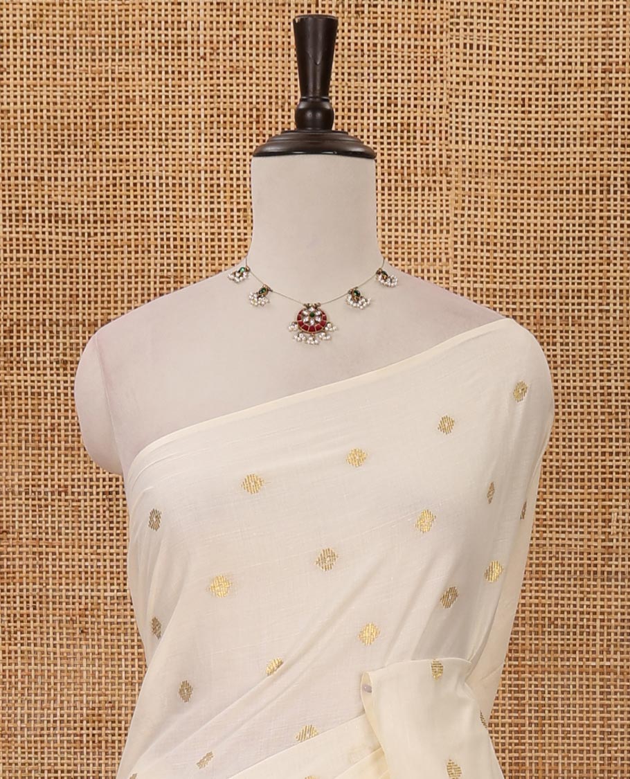 Borderless Kerala cream all over zari buttas saree, zari design pallu with green tussels & zari buttas blouse