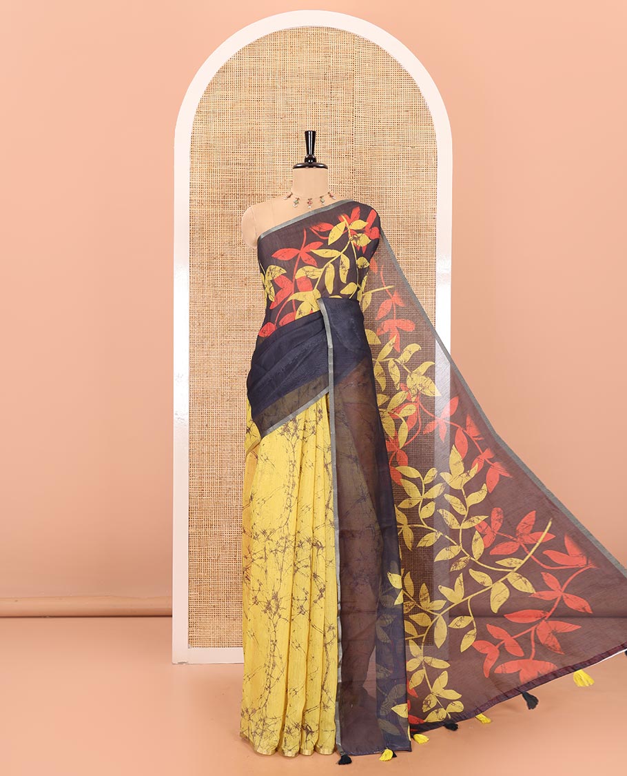 Yellow and black batik print and leaf vine printed linen saree, zari piping border, printed pallu, and a contrast batik printed blouse