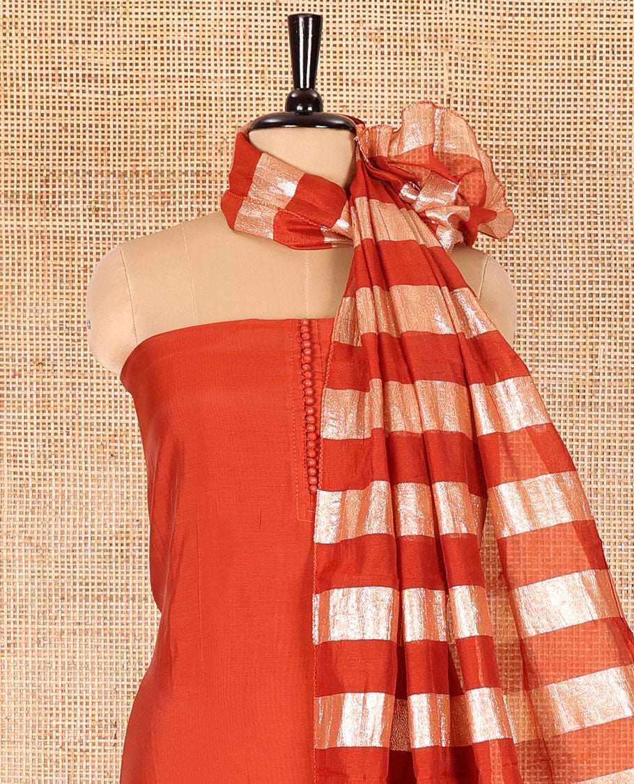 Rust material chudidar set, plain with pom-pom tasseled mul chanderi top, a matching bottom, and organza dupatta of stripes
