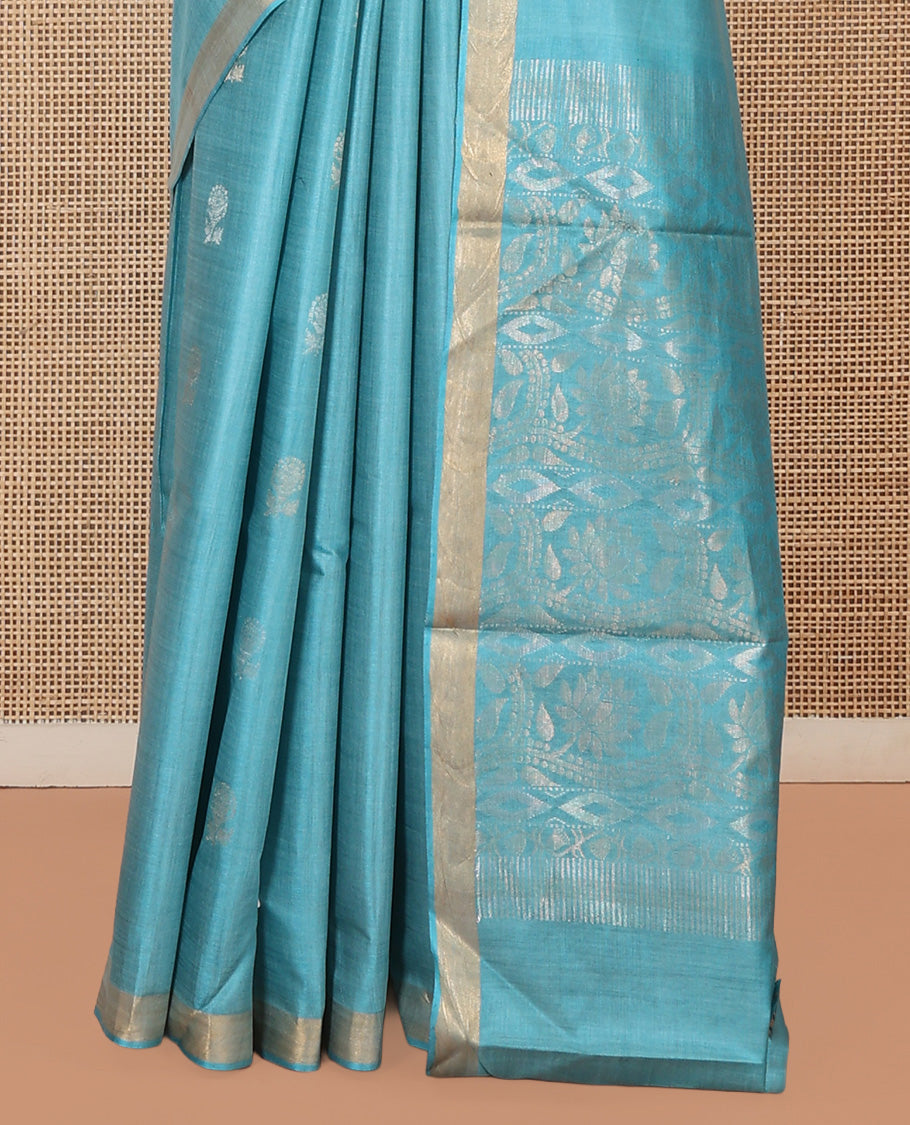 Blue Tussar Saree, Bedecked with Buttas, a Subtle Zari Border, Pallu of Intricate Designs, and a Matching Blouse