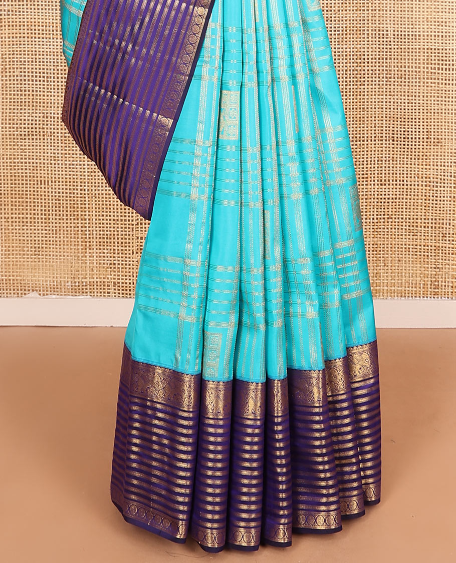 Blue zari buttas and checked Vasundhara silk mix saree, contrast varisai pettu border of salangai, yaanai, muthu, kathir, and chakram designs, and ogee patterned pallu