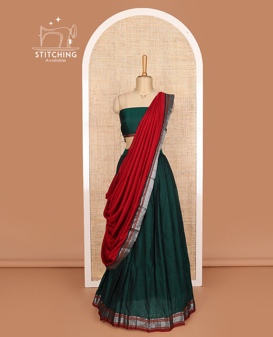 Dark green cotton half-saree, plain with contrast geometric bordered skirt, matching blouse, and contrast geometric bordered dhavani