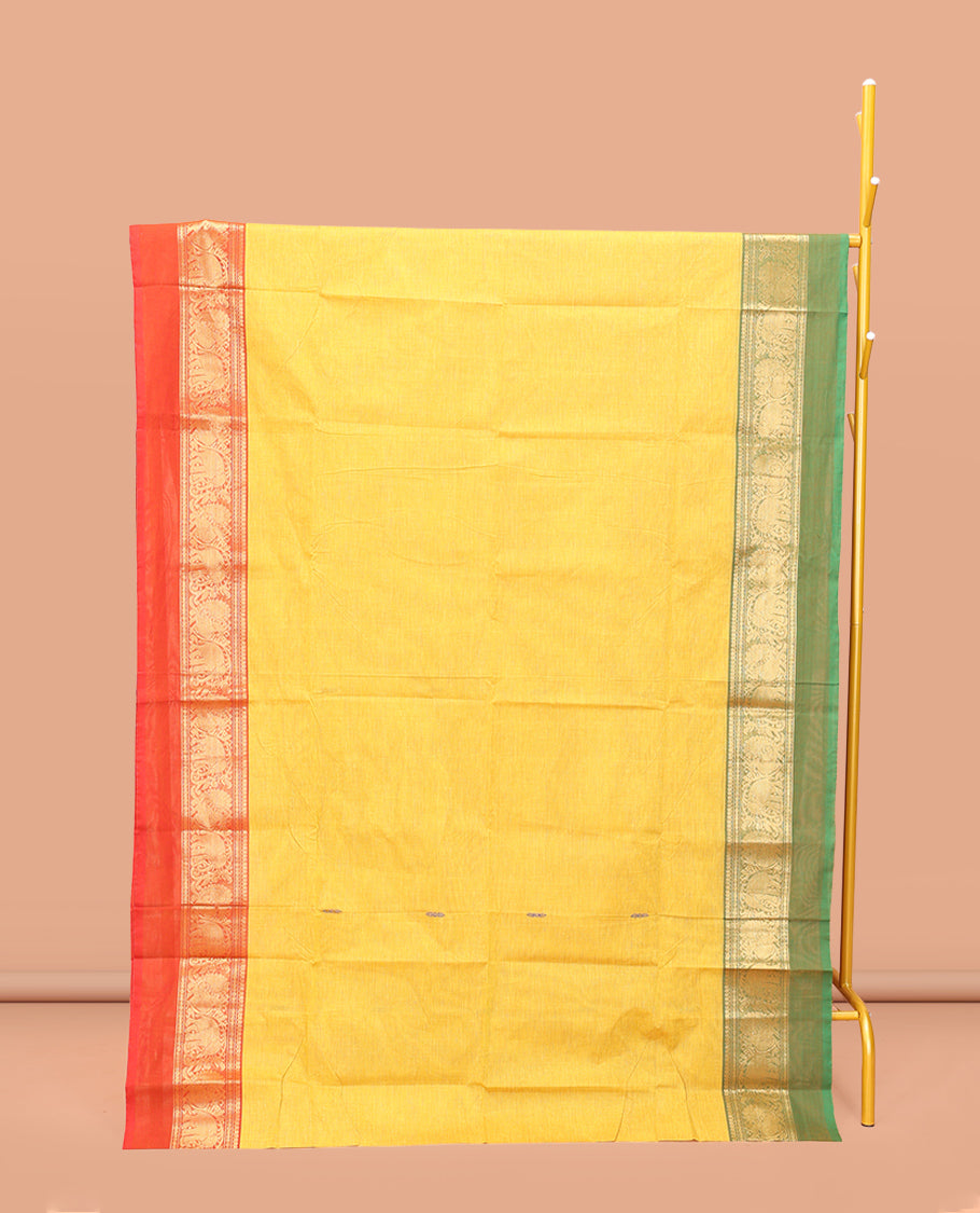 Yellow Chettinad Cotton Saree, Subtly Sparkled with Buttas All Over Its Body, Complemented by a Contrast Ganga-Jamuna Kal Eragina Border of Kodi Peacock and Elephant Designs, Pallu of Buttas and Stripes, and Paired with a Matching Blouse