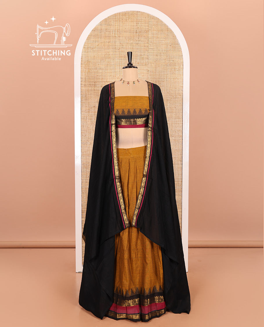 Mustard and Black Chettinad Cotton Half-Saree Featuring a Plain Skirt, Highlighted with a Contrast Traditional Zari Rettai Pettu Temple Border, a Subtly Woven Matching Blouse, and a Vichitra Silk Contrast Traditional Zari-Bordered Dhavani
