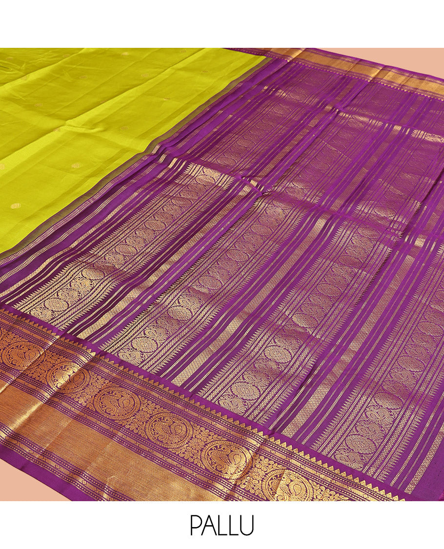 Parrot Green Vasundhara Silk Saree, Enriched with Sparse Stripes and Zari Buttas, Complemented by a Contrast Border of Thilakam, Banaras, Muthu, and Round Mayil Designs, Pallu Steeped with Traditional Designs, and Paired with a Contrast Blouse