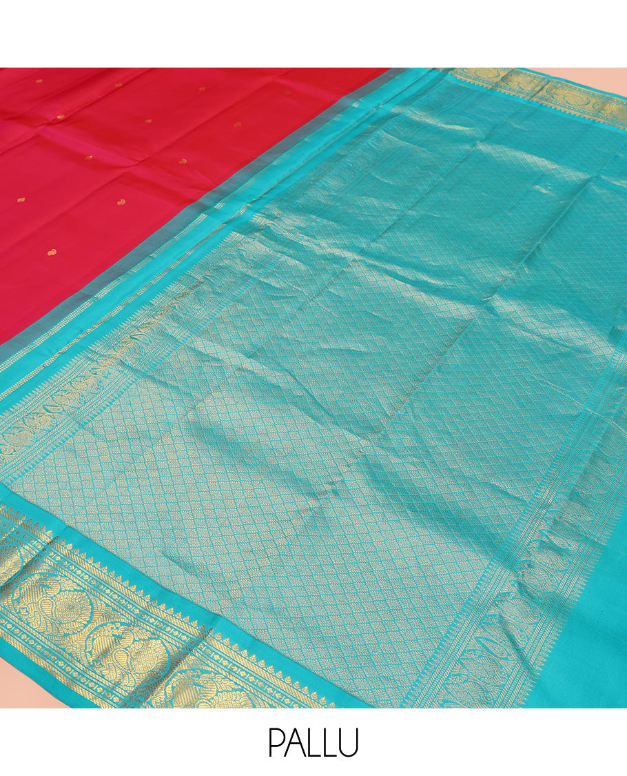 Red Vasundhara Silk Saree, Subtly Sparkled With Zari Buttas All Over Its Body, Complemented by Zari Buttas All Over Its Body, Complemented by Contrast Border of Thilakam, Banaras, and Mayil Designs Grand Jaal Pallu and Paired with a Contrast Blouse