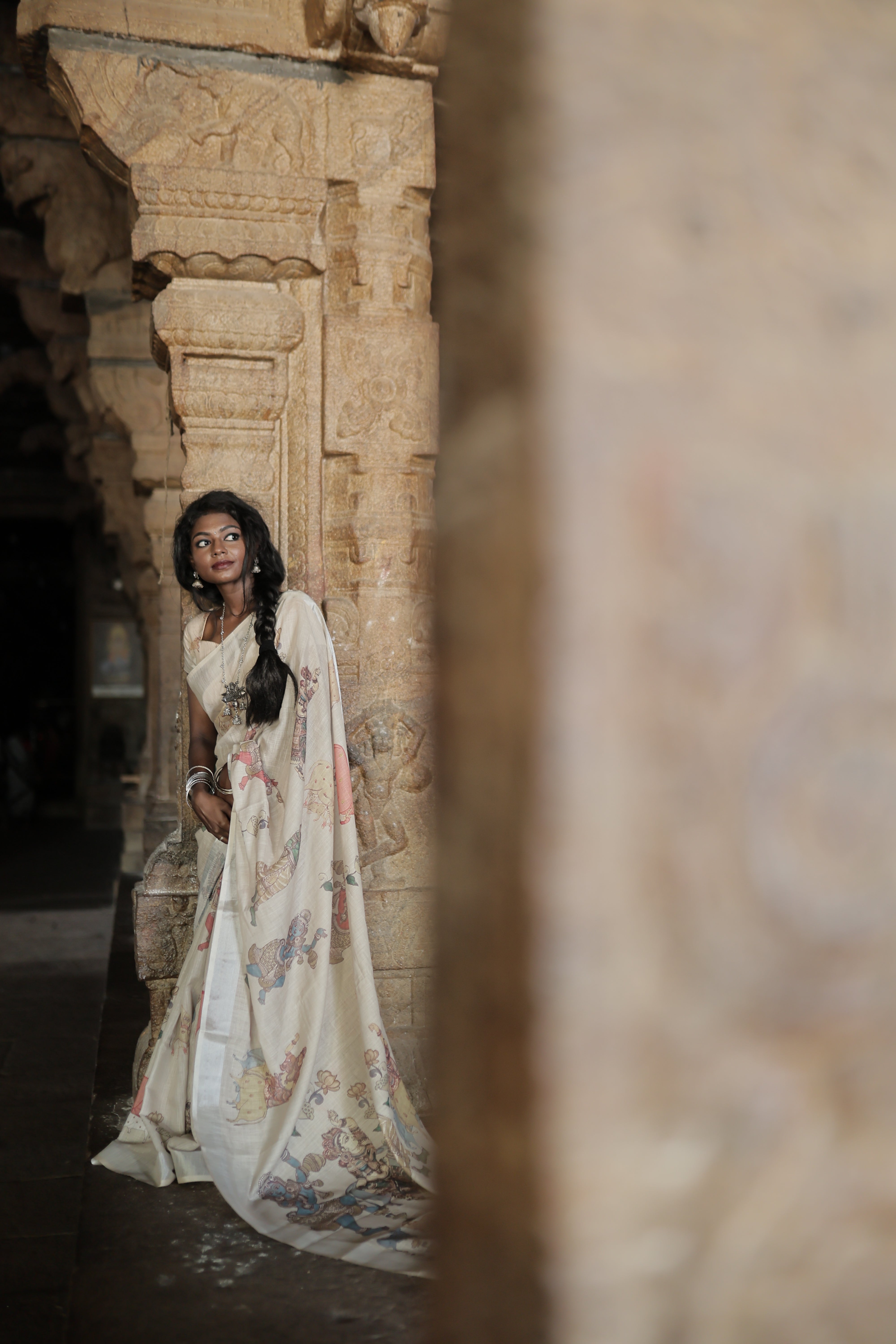 Cream Linen Saree Features Ancient Human Figurines, Floral, and Pichwai Cow, a Zari Border, Kalamkari Pallu, Matching Blouse