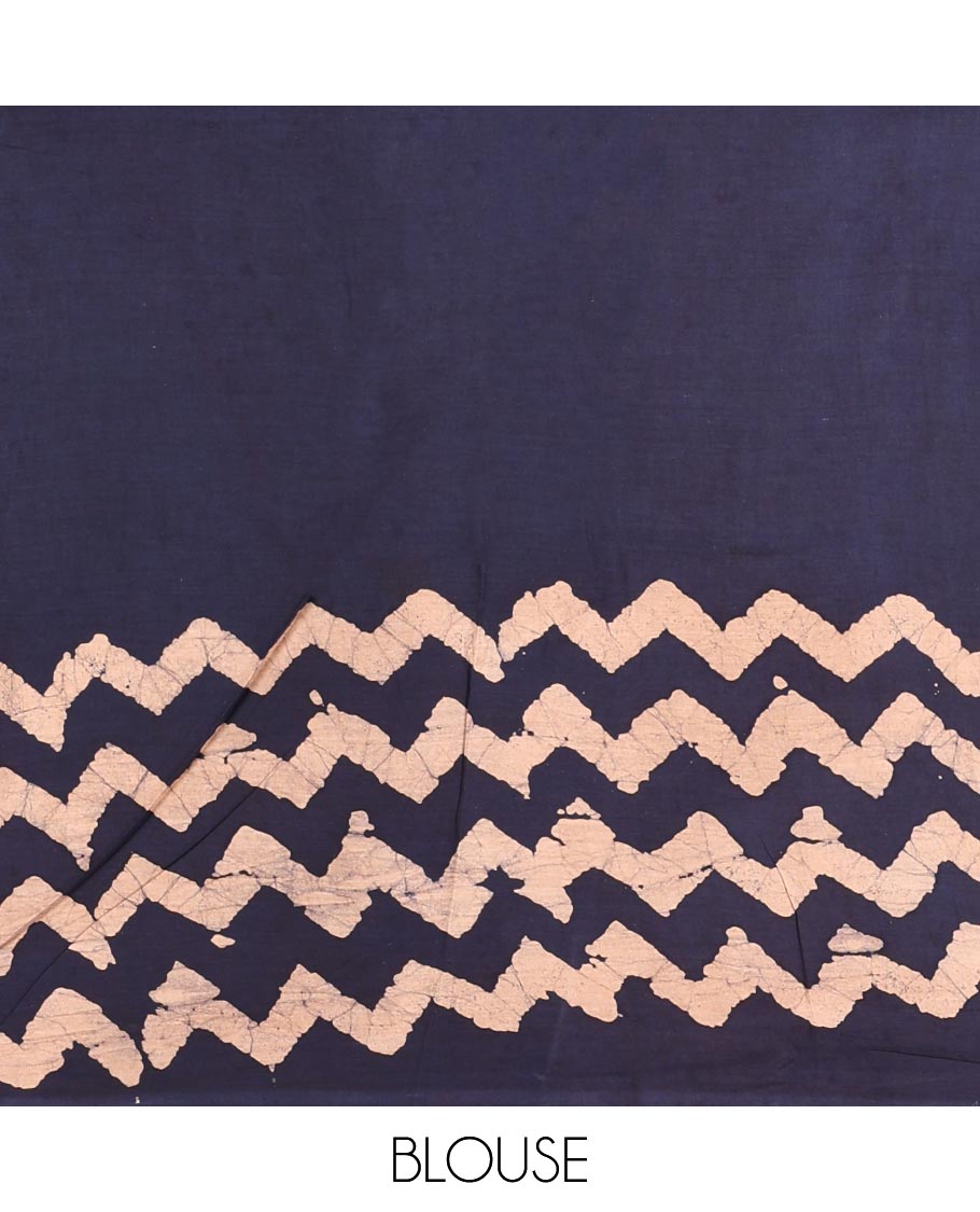 Navy blue wax batik-style zig-zag printed pure cotton saree, gold zari piping border, human figurines batik printed pallu, and a matching blouse