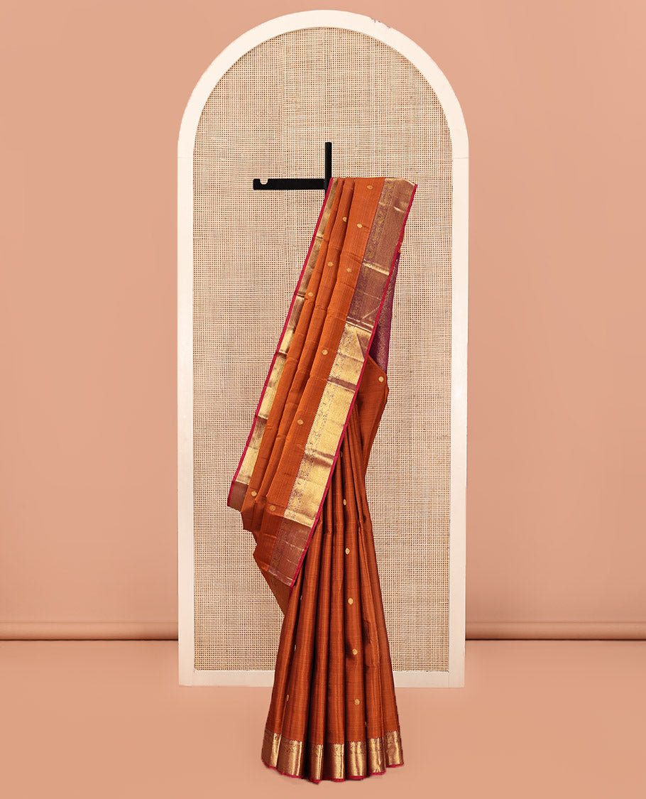 Orange Kanchipuram Silk Saree, Detailed with Chakram Buttas All Over Its Body, Complemented by Contrast Border of Rekku, Muthu, Mayil, and Yaali Designs, Pallu of Kodi Visiry and Lavangam Designs, and Paired with a Contrast Blouse