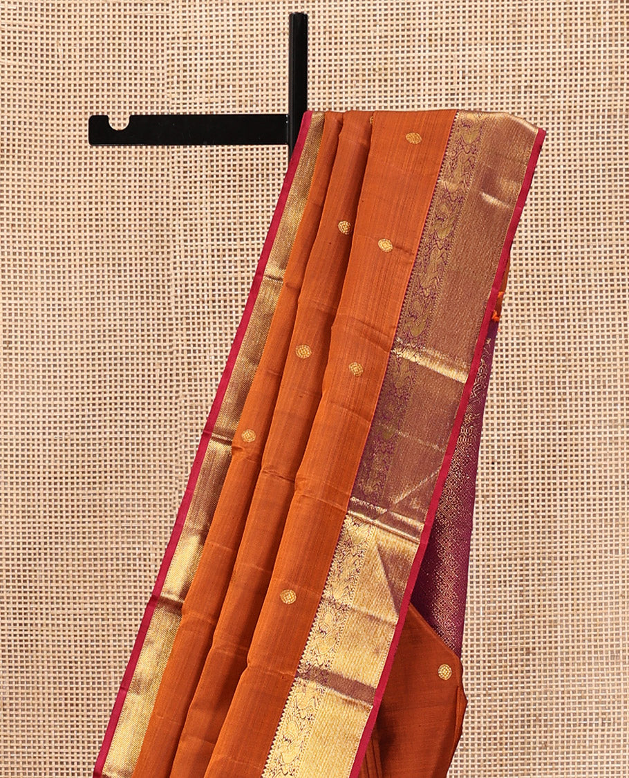 Orange Kanchipuram Silk Saree, Detailed with Chakram Buttas All Over Its Body, Complemented by Contrast Border of Rekku, Muthu, Mayil, and Yaali Designs, Pallu of Kodi Visiry and Lavangam Designs, and Paired with a Contrast Blouse