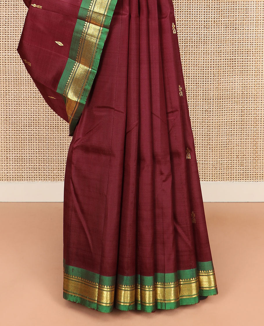 Maroon Kanchipuram Silk Saree Elevated with Zari Buttas All Over Its Body, Complemented by Contrast One-Sided Border of Rekku, Banaras, and Mayil Kann Designs, Pallu of Zari Designs, and Comes Without a Blouse