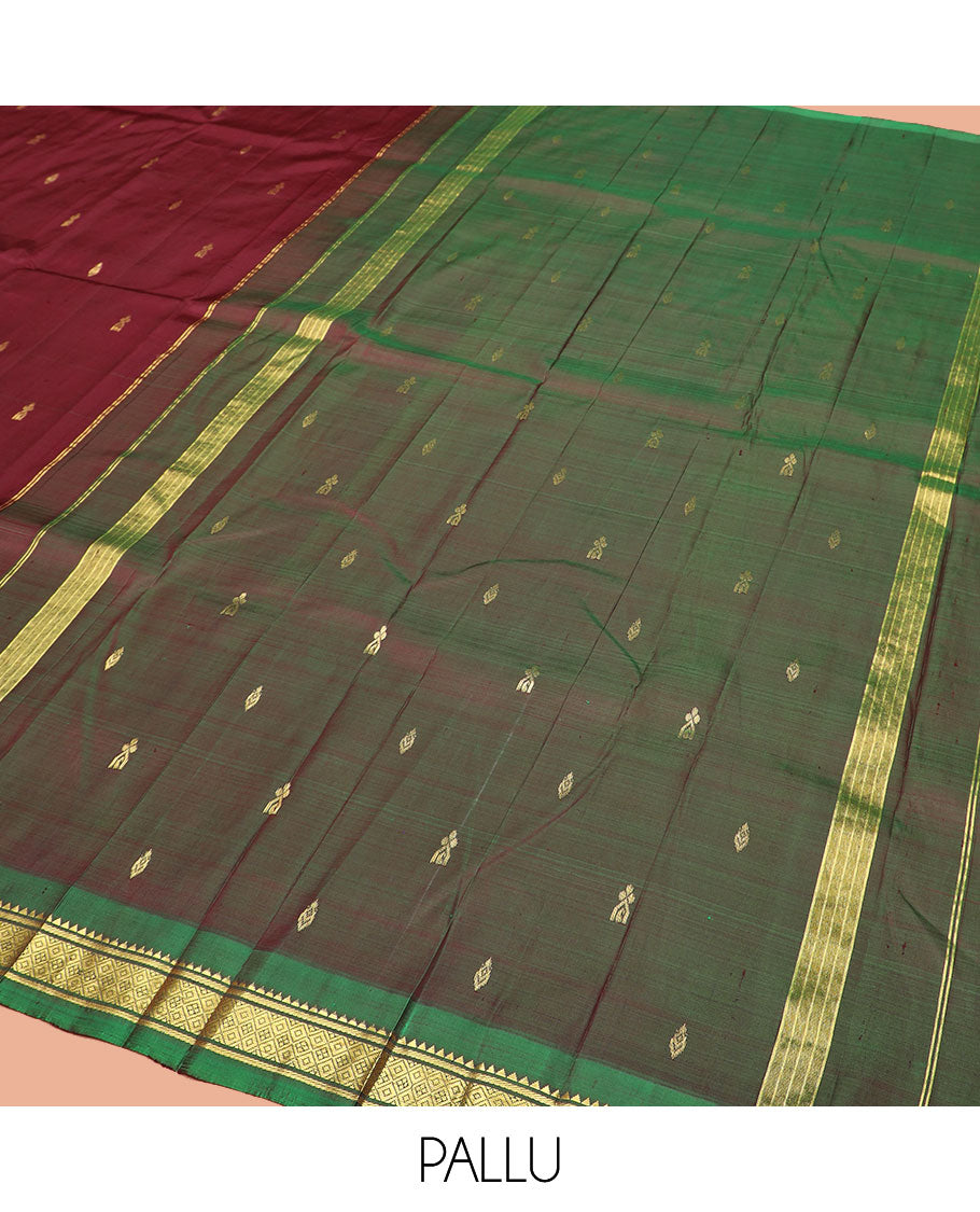 Maroon Kanchipuram Silk Saree Elevated with Zari Buttas All Over Its Body, Complemented by Contrast One-Sided Border of Rekku, Banaras, and Mayil Kann Designs, Pallu of Zari Designs, and Comes Without a Blouse