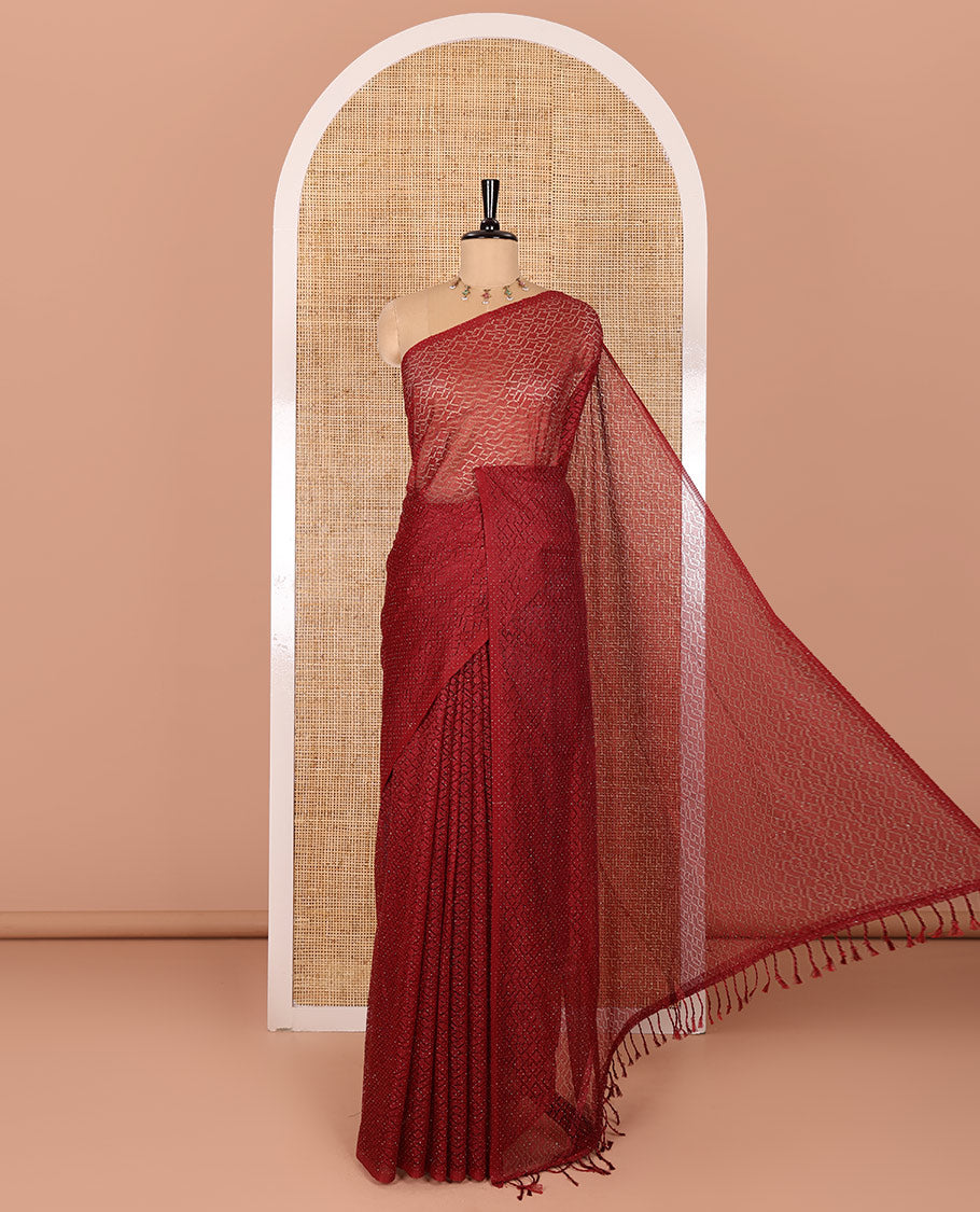 Borderless maroon sparkling glitter russel net saree with self-pallu, and a contrast floral printed and zig-zag patterned blouse
