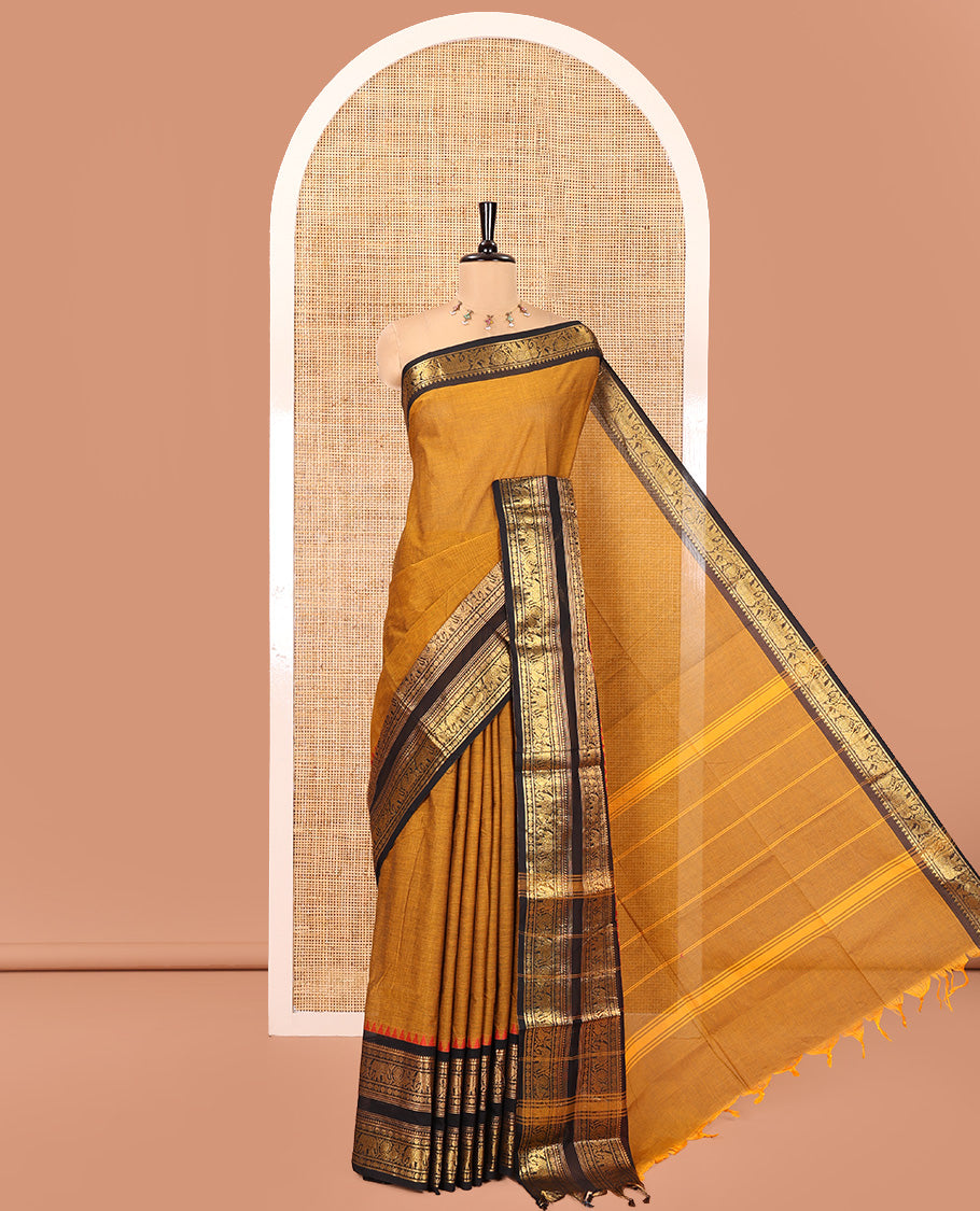 Mustard Plain Chettinad Cotton Saree, Complemented by a Contrast Rettai Pettu Red-Thread-Temple Border of Coin, Elephant, and Peacock Designs, Subtly Striped Pallu, and Paired with a Matching Blouse