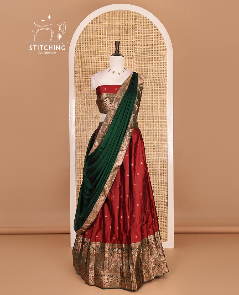 Maroon taffeta silk half saree, zari buttas with contrast green traditional zari border skirt, matching zari design blouse, and contrast plain zari border syska georgette dhavani