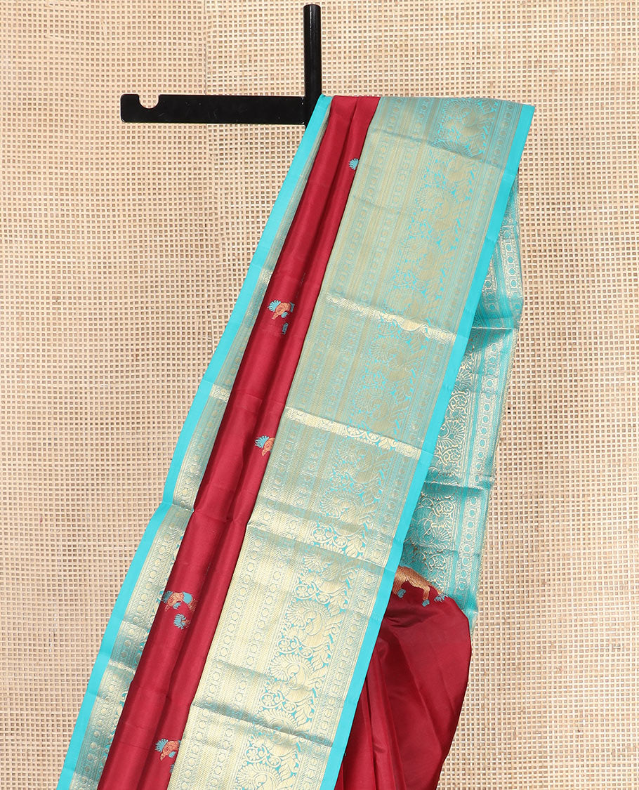 Red Vasundhara Silk Saree, Traditionally Decked up with Navagunjara Buttas, Complemented by a Contrast Border of Rekku, Kathir, Rudraksham, Muthu, and Mayil Designs, Adorned with a Pallu of Jaal Design, and Paired with a Contrast Blouse