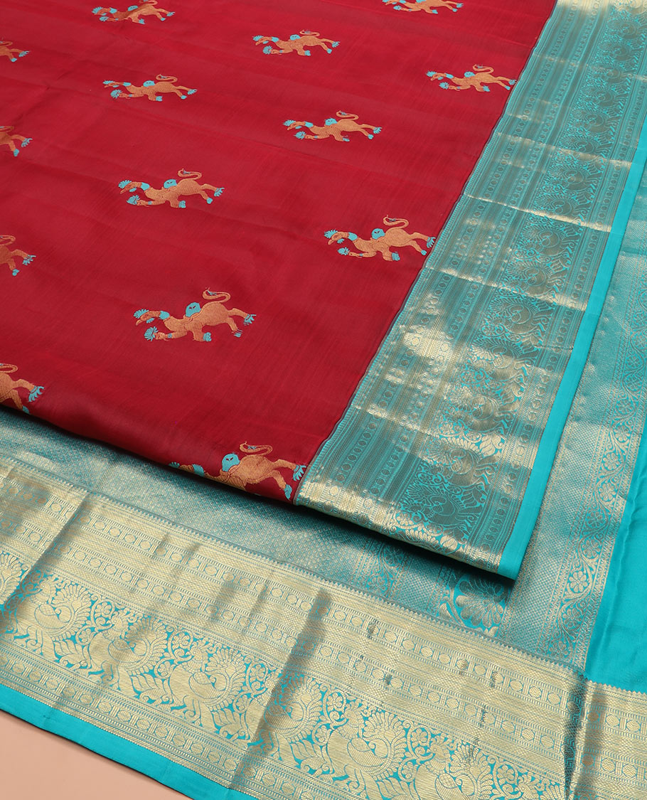 Red Vasundhara Silk Saree, Traditionally Decked up with Navagunjara Buttas, Complemented by a Contrast Border of Rekku, Kathir, Rudraksham, Muthu, and Mayil Designs, Adorned with a Pallu of Jaal Design, and Paired with a Contrast Blouse
