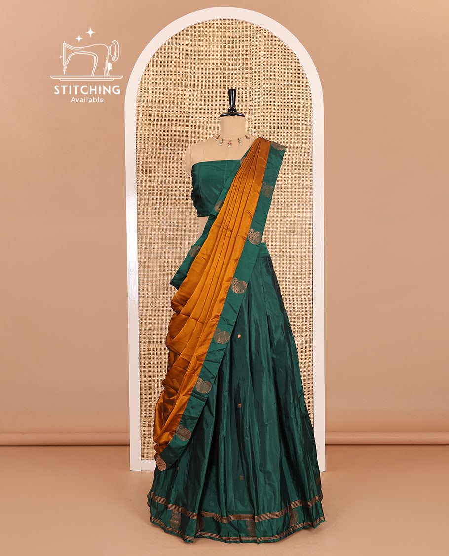 Green half-saree, buttas with self-bordered taffeta silk skirt, a plain blouse, and a contrast manga buttas bordered satin georgette dhavani