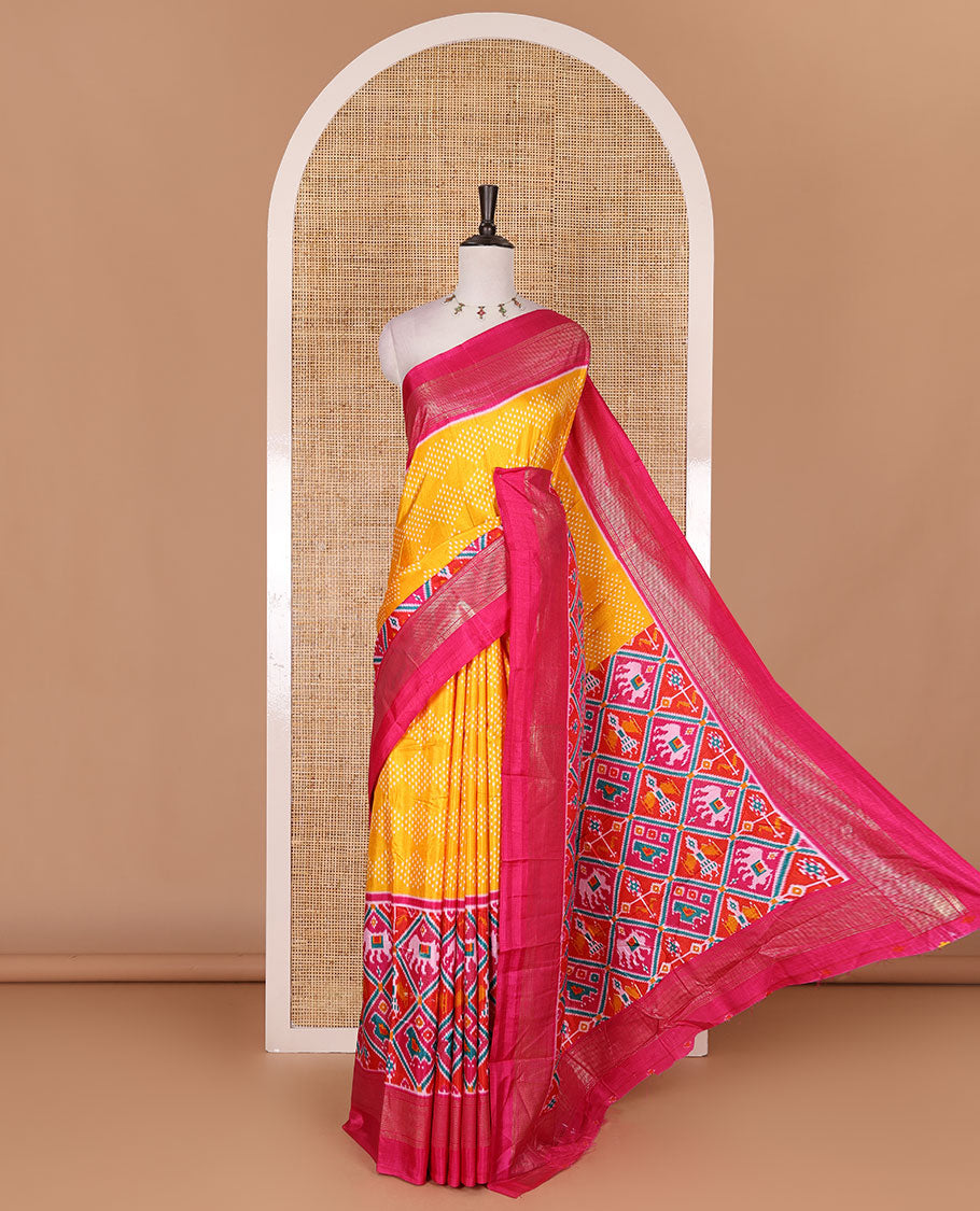 Yellow bandhani dotted dola silk saree, contrast patola style animal motifs enclosed diamond gird zari border, and contrast printed blouse