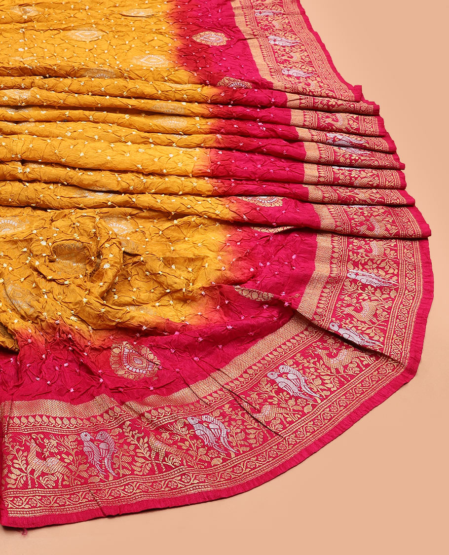 Yellow bandhani dots and zari buttas bandhani silk saree, contrast flora-fauna motifs woven border, and patola elephant enclosed ogee patterns