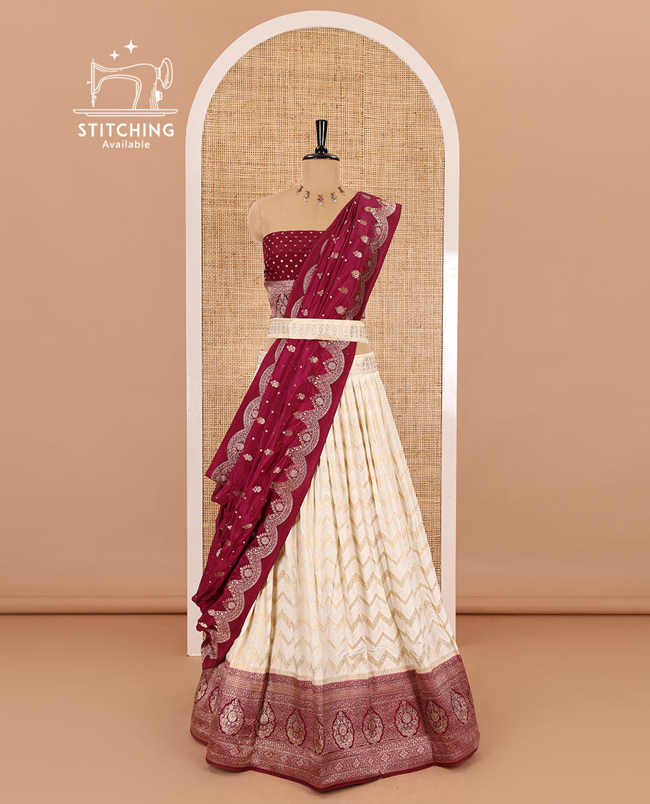 Cream-maroon chiniya crepe half-saree, chevron zari jacquard with contrast intricate patterned stone work bordered skirt, contrast blouse, and a scallop bordered intricate dhavani