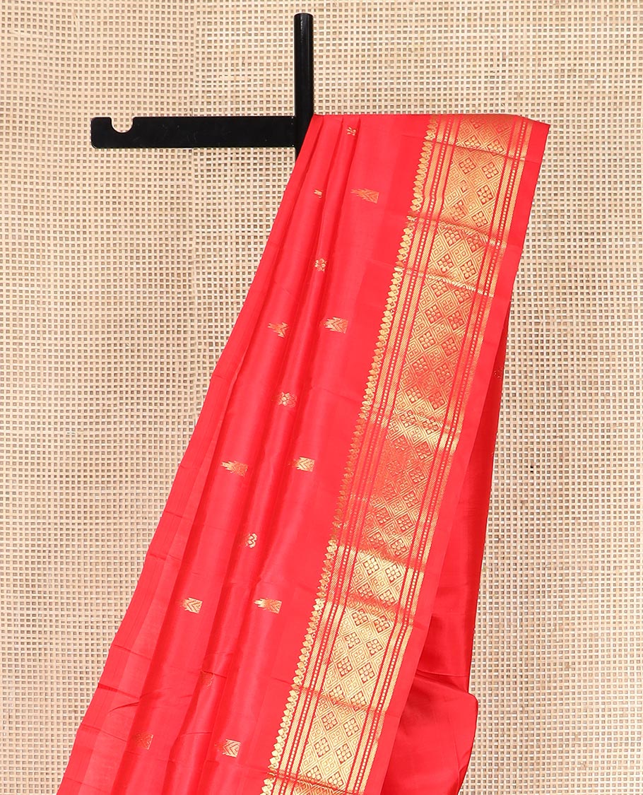 Red Kanchipuram Silk Saree Spotlighted with Zari Buttas All Over Its Body, Highlighted by Zari One-sided Border Featuring Thilakam Mokku, Banaras, Muthu, and Jaal Designs, Zari Design Pallu, and Comes Without a Blouse
