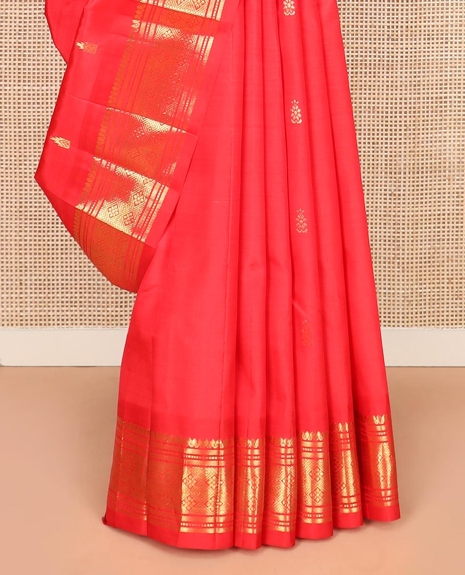 Red Kanchipuram Silk Saree Spotlighted with Zari Buttas All Over Its Body, Highlighted by Zari One-sided Border Featuring Thilakam Mokku, Banaras, Muthu, and Jaal Designs, Zari Design Pallu, and Comes Without a Blouse