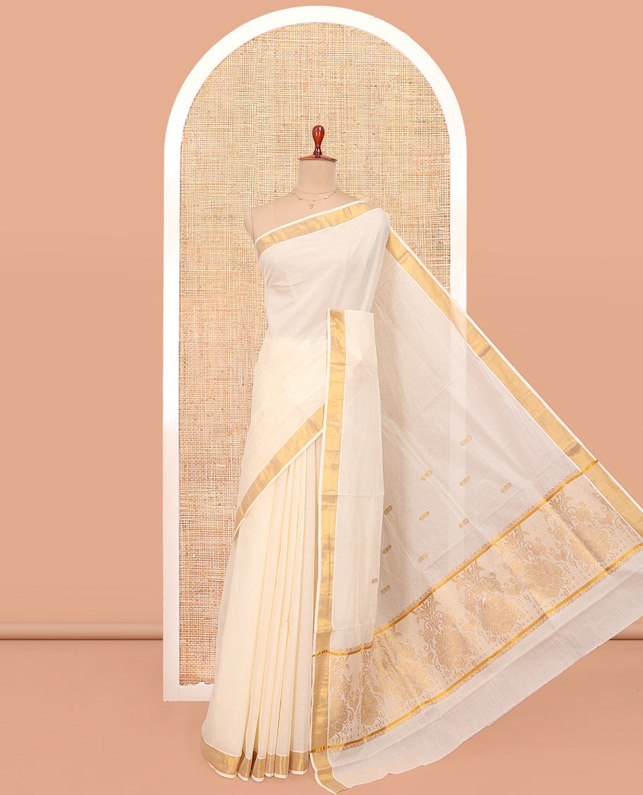 Cream Kerala Cotton Saree, Woven with Zari Buttas All Over Its Body, a Zari Bavanji Border, Pallu of Zari Designs, and Paired with a Matching Blouse
