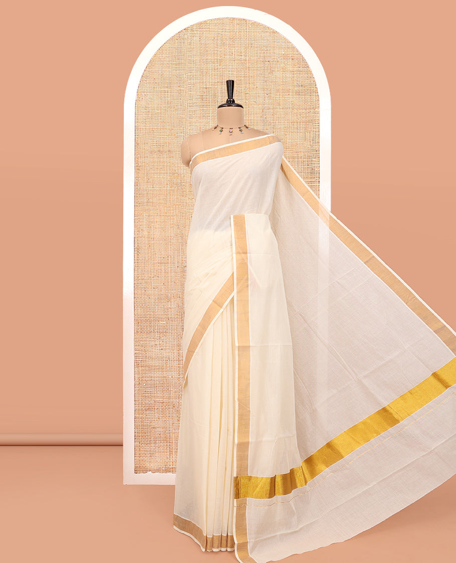 Cream Plain Kerala Cotton Saree, a Subtle Bavanji Border, Gleaming Zari Pallu, and Is Paired with a Matching Blouse