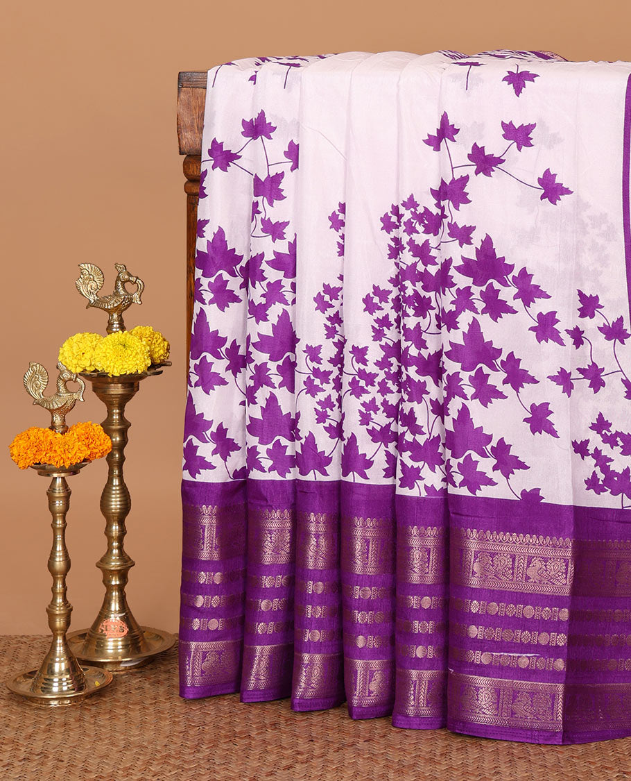 White leaf printed dola silksaree,contrast gold zari border of traditional motifs, geometric printed pallu & printed violet blouse