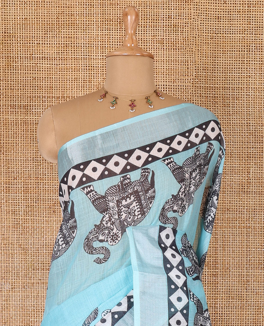 Blue plain linen cotton saree, silver zari border of elephant motifs print, elephant motifs pallu, and a contrast elephant motifs printed blouse