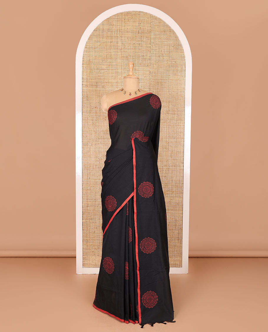 Borderless black rangoli-style chakram motifs printed South cotton saree with a matching blouse, and a contrast floral printed blouse