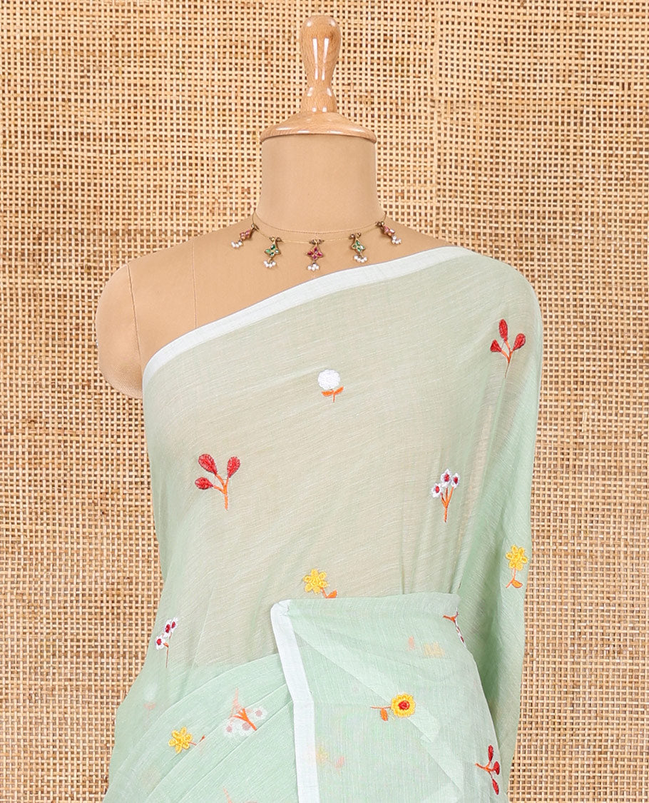 Borderless pista green floral motifs thread embroidered khadi mul cotton saree, floral motifs thread embroidered pallu, and a matching plain blouse